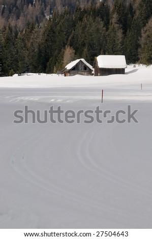 Winter landscape with 2 barn in the sunlight