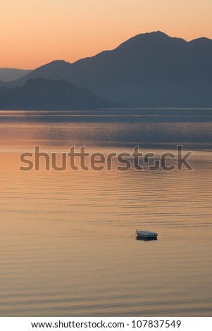 Lonely boat in the sea on sunrise  in a calm. Pastel tones. Marmaris. Turkey.