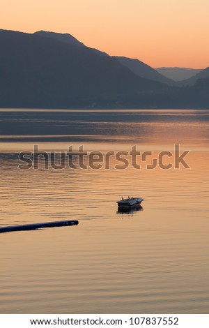 Lonely boat in the sea on sunrise  in a calm. Pastel tones. Marmaris. Turkey.