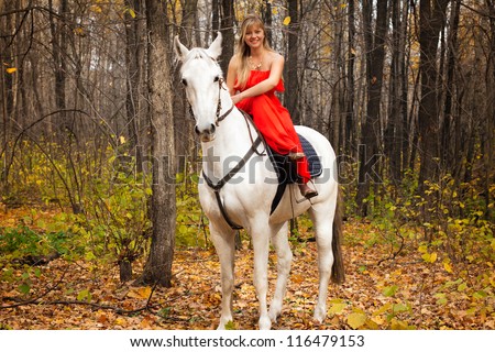 fine young woman in long red dress on horseback on white horse