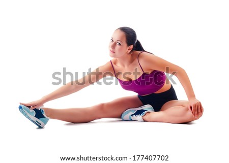 beautiful woman in sportswear does exercises sitting on floor on white background