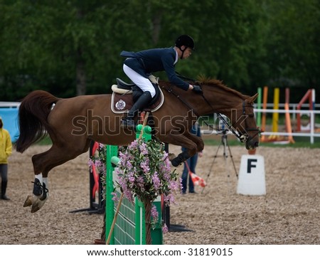 MOSCOW - MAY 16: Rider on his horse  jumps over the barrier in CSKA Summer Showjumping Cup event May 16, 2009 in Moscow, Russia