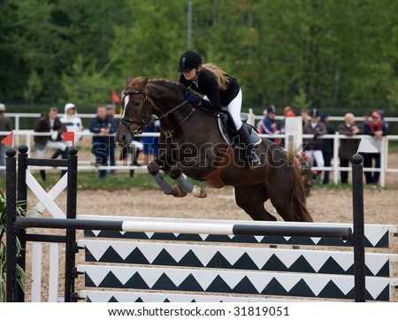 MOSCOW - MAY 16: Rider on her horse  jumps over the barrier in CSKA Summer Showjumping Cup event May 16, 2009 in Moscow, Russia