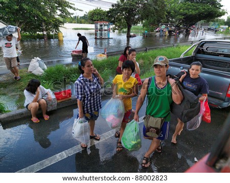 PHATHUMTRANI, THAILAND- OCTOBER 21: Family leaves their home during the worst flooding disaster in decades. in decades on October 21, 2011 Rongsit Road, Phathumtrani, Thailand.