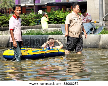 PHATHUMTRANI, THAILAND- OCTOBER 21: Volunteers rescue worker  help elderly woman  in the streets of  city, during  worst flooding in decades on October 21, 2011 Rongsit Road, Phathumtrani, Thailand.