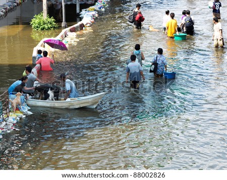 PHATHUMTRANI, THAILAND- OCTOBER 21: Families leave their home during the worst flooding disaster in decades. in decades on October 21, 2011 Rongsit Road, Phathumtrani, Thailand.