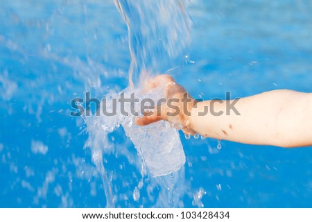 Water for life or Life for water ..Girls hand holding glass under  running blue water