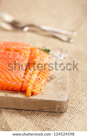 smocked salmon homemade, with spice on wooden board, shallow dof