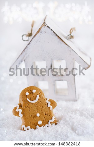 Gingerbread man and wooden house on a festive Christmas snow background, nice postcard