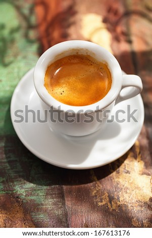 espresso coffee cup on rustic table with sun light and shadows