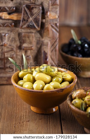 marinated Olives in bowls with moroccan  ornament on wood, shallow dof