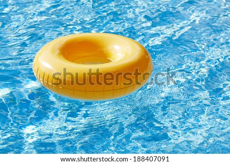 floating ring on blue water swimpool with waves reflecting in the summer sun