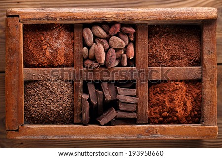 old spicy box full of chocolate - cocoa and sugar, cocoa beans, grated chocolate, hot chocolate flakes, solid pieces, dark cocoa powder