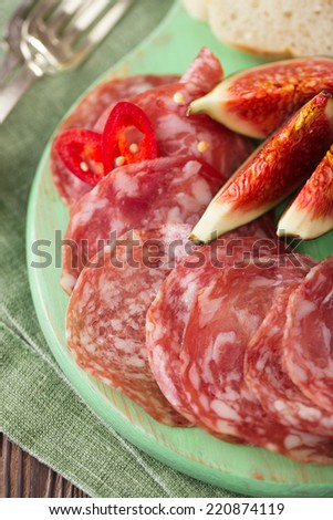 meat platter of Cured Meat and figs on green wooden board