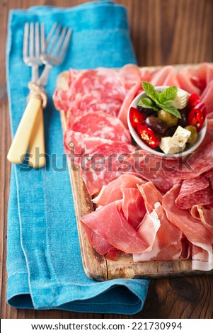 meat antipasti Platter of Cured Meat,   jamon, olives, sausage, salami  on old wooden board