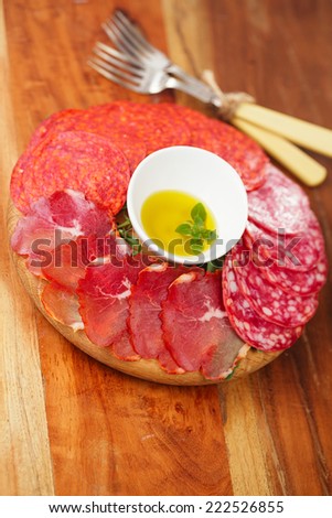 meat platter of Cured Meat and salami on round wooden board