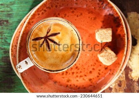 A cup of spiced coffee with anise star and soucers in vintage  rustic style