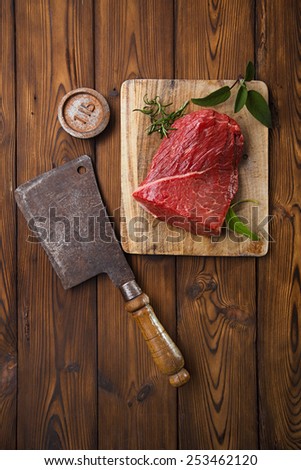 raw beef meat fillet  on wooden  table with meat cleaver and 1lb iron weight