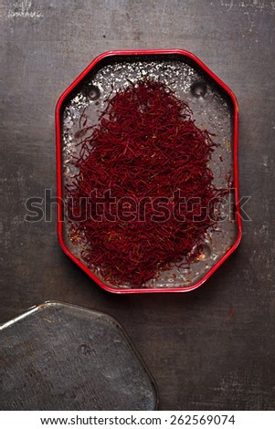 saffron spice threads   in vintage  old tin,  old metal background, closeup
