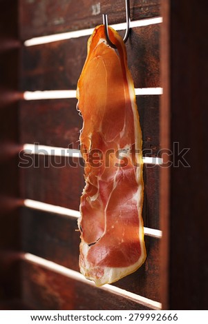 piece of serrano ham jamon Cured Meat hanged on hook