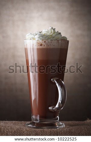 Hot Chocolate with cream in Tall Glass on brown rustic background, Low Key  Lighting Technique