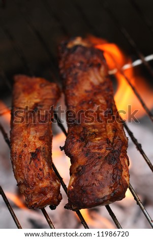 flame bbq chinese style juicy pork ribs on grill - summer barbeque food