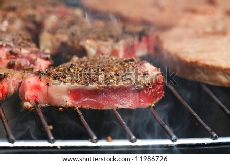 ready to bbq spiced raw lamb chop with smoke on grill - summer barbeque food, shallow DOF
