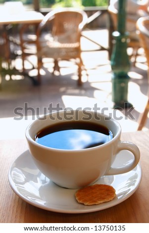 black coffee cup with biscuit and morning cafe background