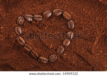 coffee beans in heart shape and ground background, warm light