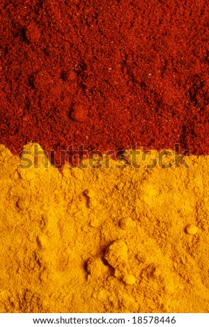 two color spices - pile of ground turmeric and paprika, background