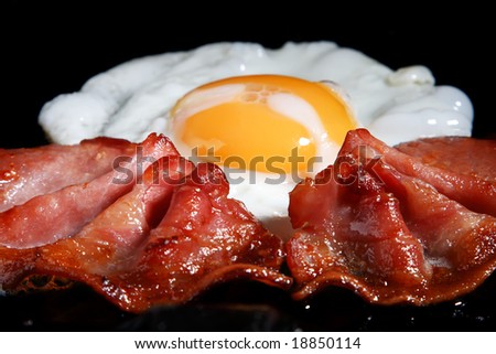 frying egg and two bacon rashers, shallow DOF