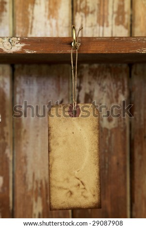 old paper tag with string hanged on on hook in old  wooden cupboard, shallow DOF