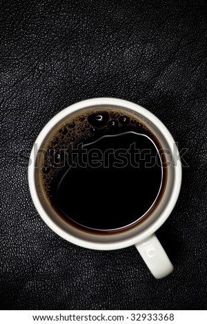 good night espresso coffee in white cup top view, black leather backdrop, shallow DOF