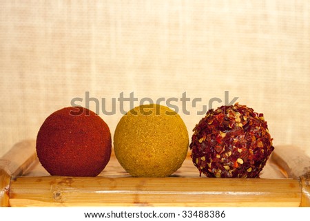 paprika, hot curry powder and crushed chillies in balls shape on old bamboo table, shallow DOF