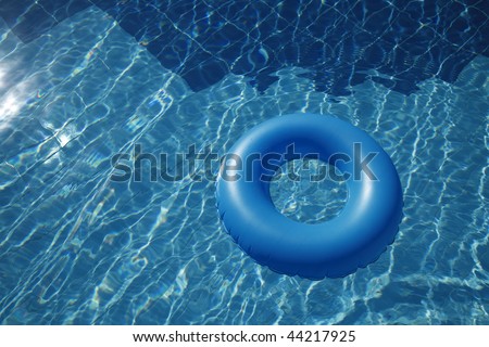 floating inner tube in a pool with waves reflecting in the summer sun