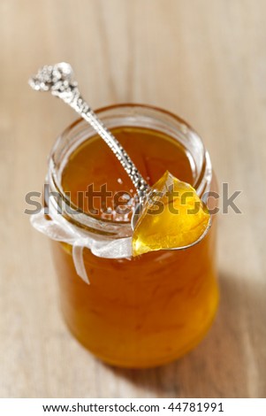 orange   thin cut marmalade or jam on a spoon in a jar, shallow DOF