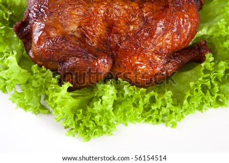 homemade hot smoked whole chicken on leaf lettuce bed isolated on white