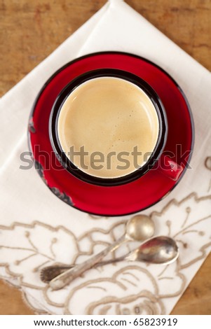 espresso coffee in red enamel mug, two old silver spoons, embroidered nupkin, shallow dof