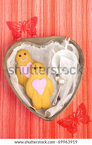 gingerbread boy and girl on tin heart shaped tray, red linen striped with butterfly backdrop