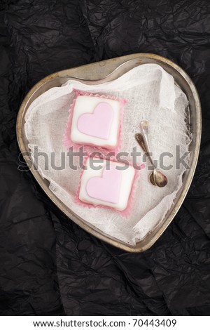pink cupcakes in heart shaped tin,black paper background