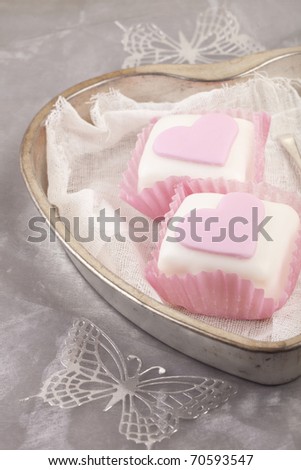 heart shaped pink cupcakes in  tin tray with gray shine background