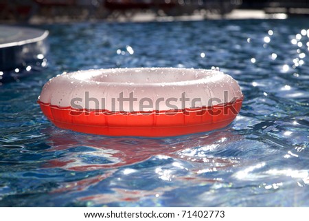 floating  ring on blue water swimpool with waves reflecting in the summer sun