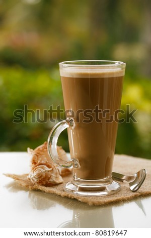 coffee latte in sky, palm tree and sunset background, warm light, shallow dof