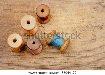 real old reels spools with color treads on old wooded background