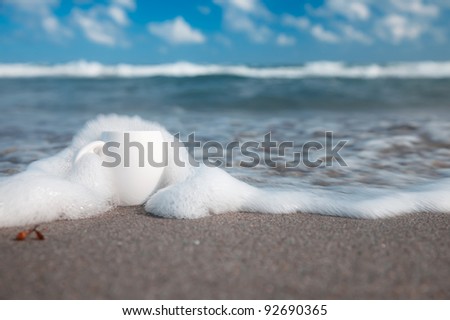 espresso coffee in white cup with ocean wave, beach and seascape. Shallow dof.