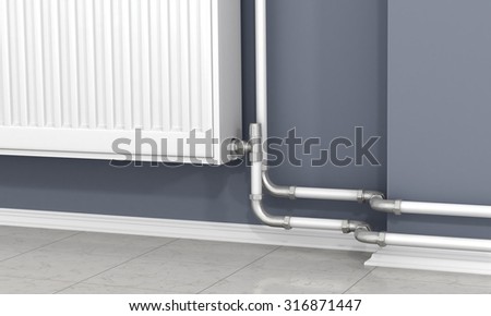 The white radiator and pipes of heating on the gray wall.