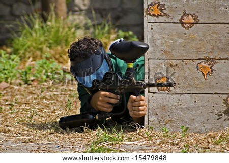 Men playing paintball behind the fence