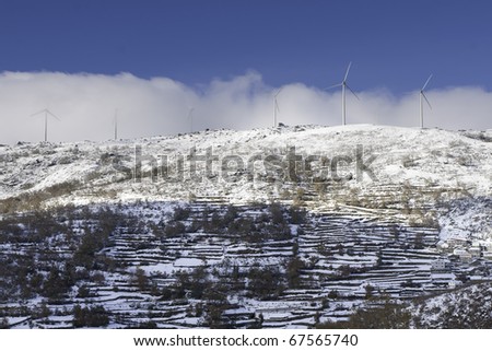 Wind turbine on top of mountain cover with snow