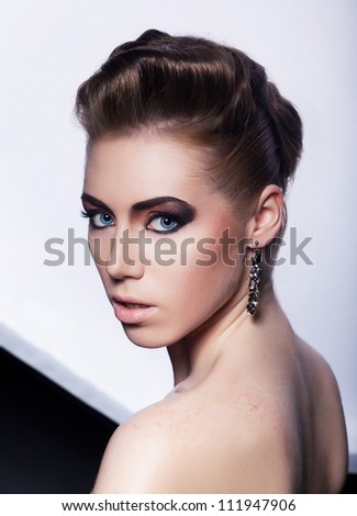 Portrait of beautiful fashionable woman with earrings - stylish styling coiffure (hairstyle)
