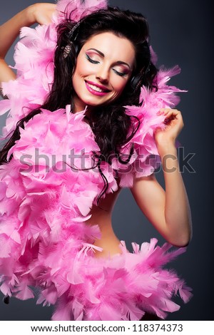 Elated positive woman in pink dress listening to the music